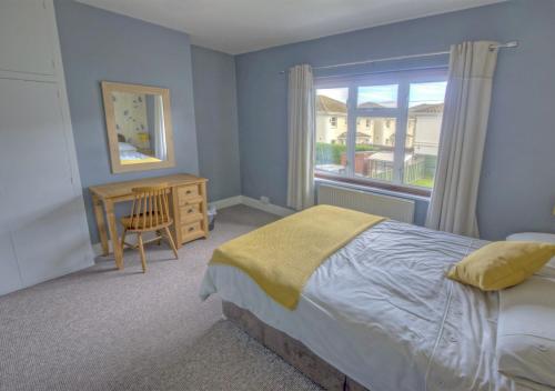 锡顿Dalmose的一间卧室配有一张床、一张书桌和一个窗户。