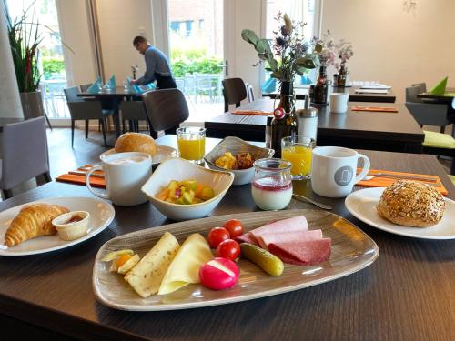明斯特Alexianer Hotel am Wasserturm的桌子上放着一盘食物的桌子