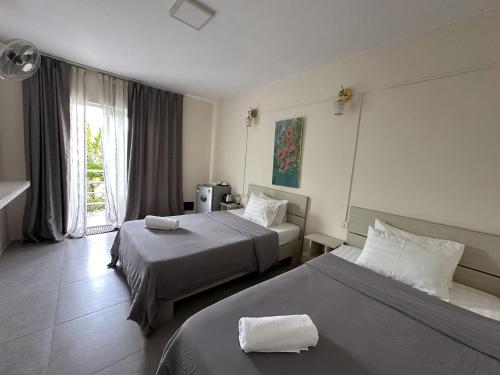 西哈努克Ginger Sihanoukville的酒店客房设有两张床和窗户。