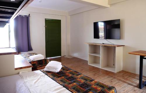 san juan la unionLone Star Inn的客房设有床、书桌和电视。