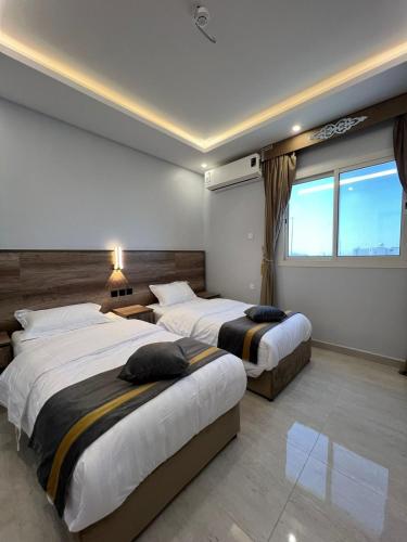 AR Rummanahبارك بلس للشقق المخدومة的酒店客房设有两张床和窗户。