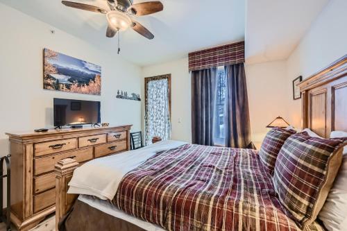 布雷肯里奇Highland Greens Lodge 210 Colorado的一间卧室配有一张床和一个带电视的梳妆台。