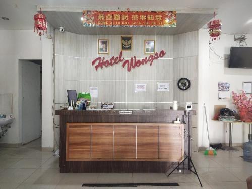 邦加槟港Capital O 93589 Hotel Wongso Syariah的墙上有标牌的带柜台的餐厅