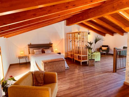 FuendetodosAPARTAMENTOS VILLA DE GOYA的一间带一张床的卧室,位于带木制天花板的房间内