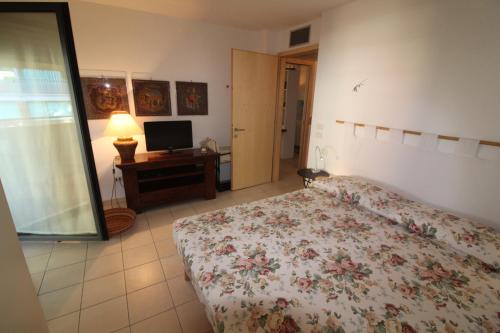 利尼亚诺萨比亚多罗Verdemare Pineta的一间卧室配有一张床和一台电视