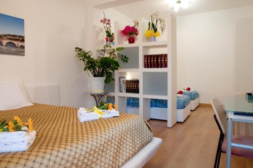 维罗纳Arena d'Intorno的一间卧室设有两张床,一个鲜花架子