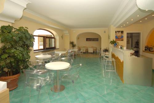 伊斯基亚伊姆帕拉马尔酒店的客房铺有瓷砖地板,配有桌椅。