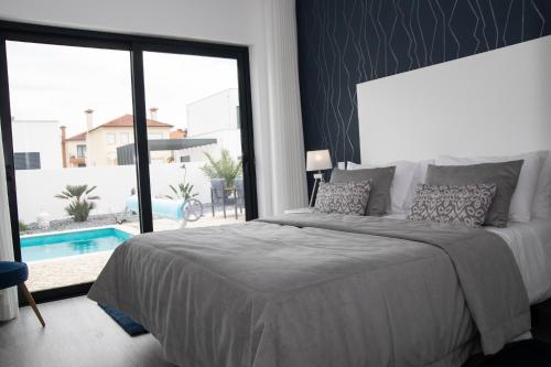 帕塔亚什Villa Besugo - SCH082的一间卧室设有一张床和一个带游泳池的大窗户