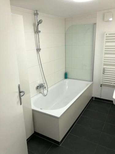 汉堡Außenalster Penthouse Charakter的带淋浴的浴室配有白色浴缸。