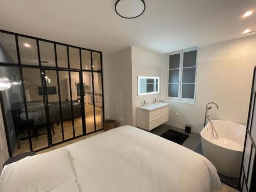 里昂Appartement pour 1à2 personnes#2的一间卧室配有一张床、一个浴缸和一个水槽