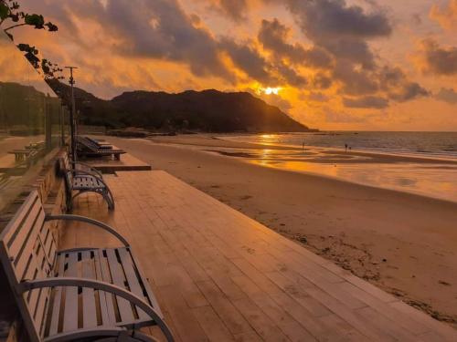 隆海安和公寓酒店的海滩上的日落,在木板路上长椅