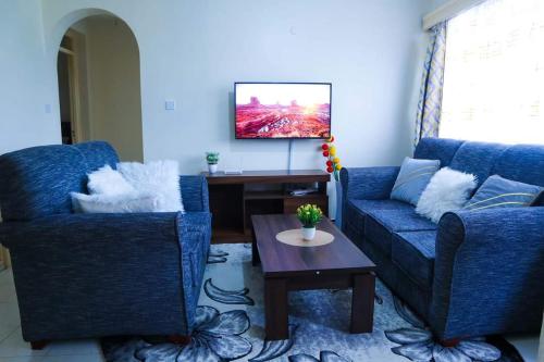 ThikaGazena homes的客厅配有2张蓝色的沙发和1张桌子