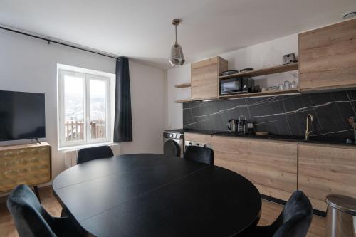 热拉梅K1, appartement avec grande terrasse et vue pistes的一间用餐室,配有黑色的桌子和椅子