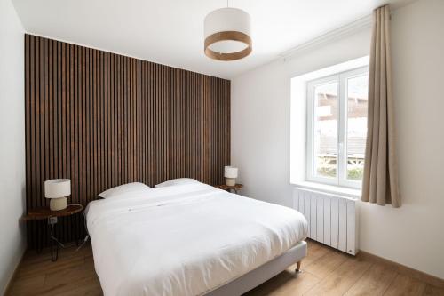 热拉梅K1, appartement avec grande terrasse et vue pistes的卧室配有白色的床和窗户。