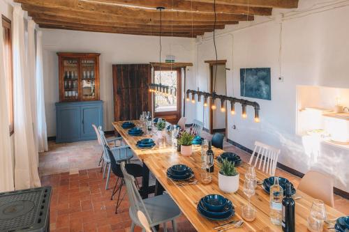 MontagutCan Riera de Montagut - Masia per 20 persones的用餐室配有长木桌子和椅子