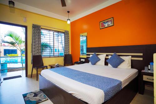 曼达莫尼Aqua Marina Drive Inn的一间卧室配有一张带橙色墙壁的大床