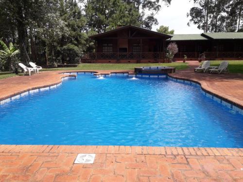 伊瓜苏港Toucan Lodge的庭院里的一个蓝色的大游泳池