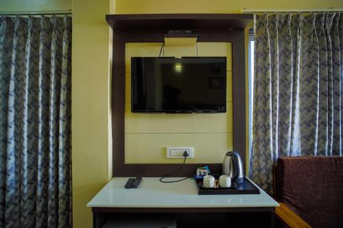 曼达莫尼Aqua Marina Drive Inn的一间设有一张桌子的房间,墙上配有电视