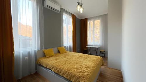 Meore BaladaGreen bunny guesthouse的一间卧室配有一张带黄色床单和窗户的床。