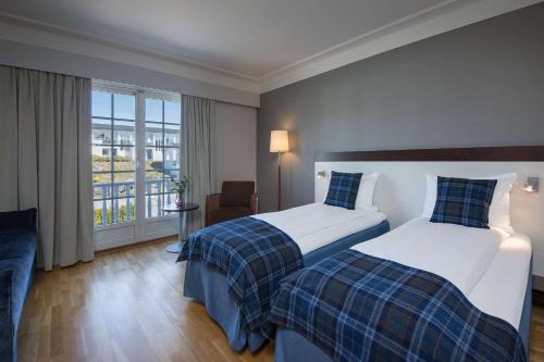 彻默岛Havna Tjøme Hotel的酒店客房设有两张床和一个阳台。