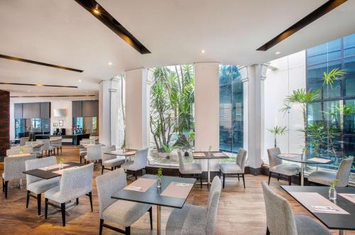 圣保罗美利亚伊比拉普埃拉酒店的餐厅设有桌椅和大窗户。
