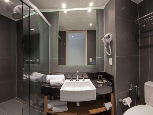 帕尔马斯ibis Styles Palmas的一间带水槽、镜子和卫生间的浴室
