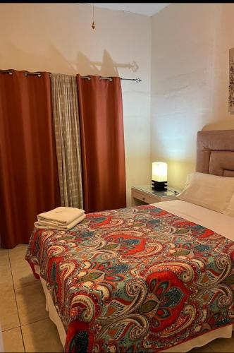 埃斯特利Hostal Rio Piedra的一间卧室配有一张带彩色毯子的床