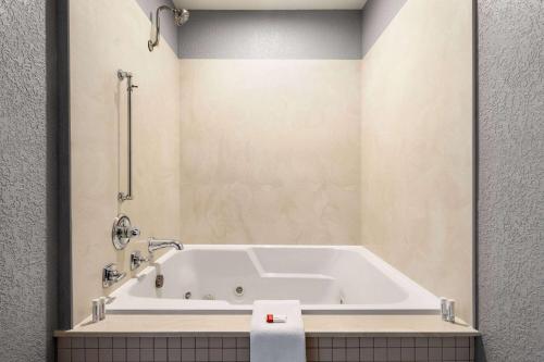WilliamsburgAmericInn by Wyndham Williamsburg的浴室铺有瓷砖地板,配有白色浴缸。