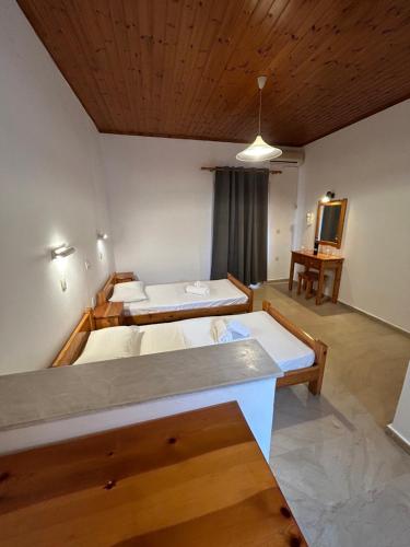 卡沃斯Kavos Panorama Complex的大房间设有两张床和一张桌子
