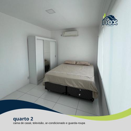 卡鲁阿鲁Nox Temporada - Flat 201 a 4km da Feira e Shopping Caruaru的一间白色客房内的床铺卧室