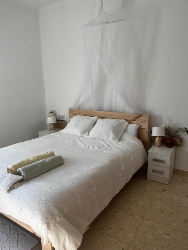 卡尔多纳Can Bastida的卧室配有一张带白色床单和枕头的大床。