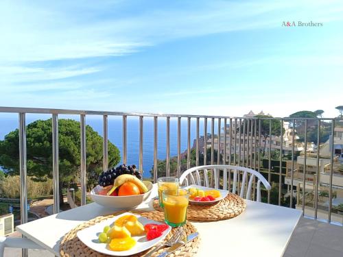 萨卡罗A&A Brothers S'Agaró Bay的阳台上的桌子上放着一碗水果和饮料
