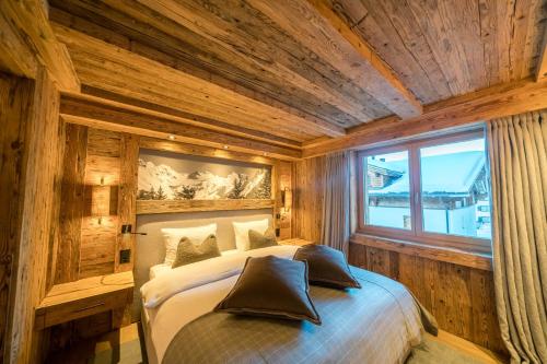 克洛斯特斯瑟纽斯Seven Alpina Boutique Hotel的卧室配有一张床铺,位于带木墙的房间内
