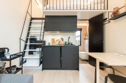 埃丹KODA Edam的厨房配有黑色橱柜和螺旋楼梯