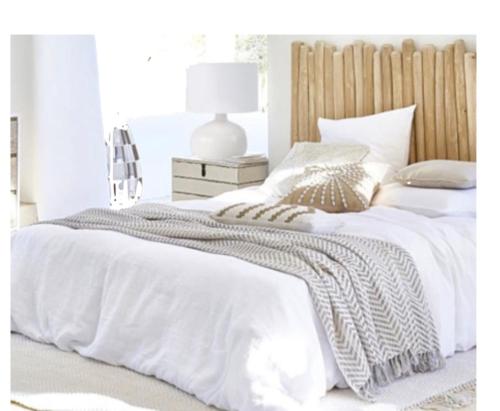 奥龙Appart Hôtel - Nature et Spa的卧室配有白色的床和木制床头板
