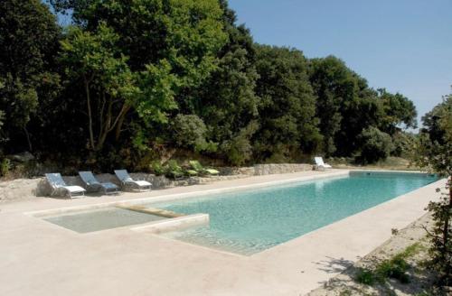 奥龙Appart Hôtel - Nature et Spa的一个带2把躺椅和树木的游泳池
