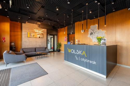 华沙City Break Wolska Aparthotel的大厅配有沙发,前台位于大楼内