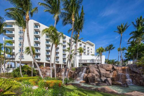 棕榈滩希尔顿阿鲁巴加勒比赌场度假酒店的拥有瀑布和棕榈树的酒店