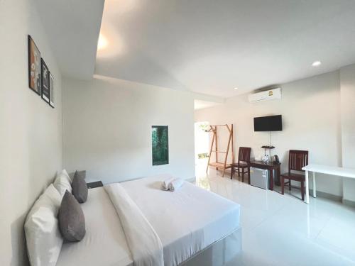 Ban Huai Sua绿色度假村 的白色卧室配有床和桌子
