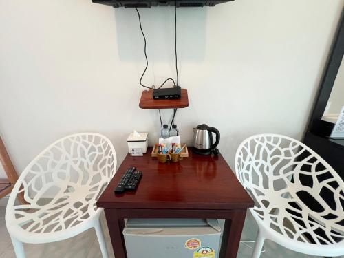 Ban Huai Sua绿色度假村 的一张带两把椅子的小桌子和咖啡壶