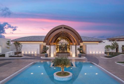 拉斯阿尔卡麦Anantara Mina Al Arab Ras Al Khaimah Resort的一座别墅,在一座建筑前设有一个游泳池