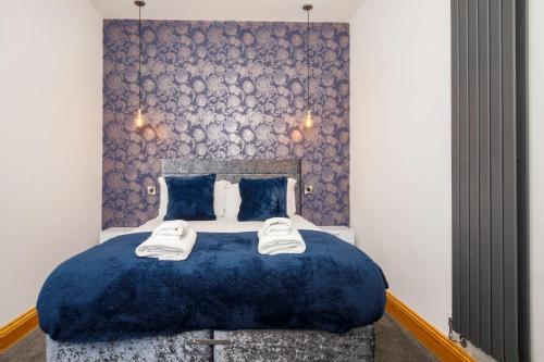 约克The Retreat At The Lawrence Apartments的一间卧室配有蓝色的床和2条毛巾