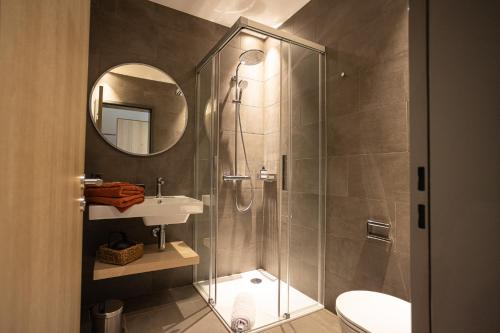 PorzaLocanda della Masseria的带淋浴、盥洗盆和镜子的浴室