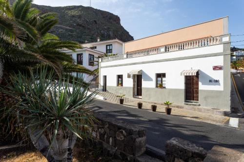 San Juan de la RamblaEl Hostal del Cubo的一座白色的建筑,前面有棕榈树