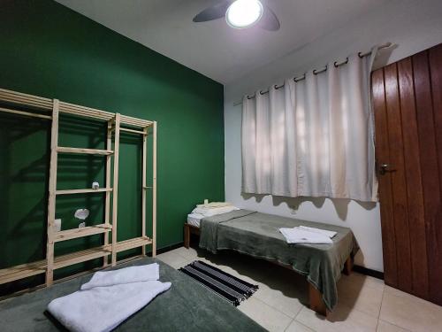 塞拉Refugio em costa bela Beach的绿色的客房设有两张床和窗户。