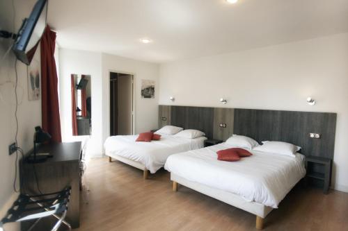 圣塞雷Le Victor Hugo - Hôtel et Restaurant - Logis Hôtels的一间卧室配有两张带白色床单和红色枕头的床。