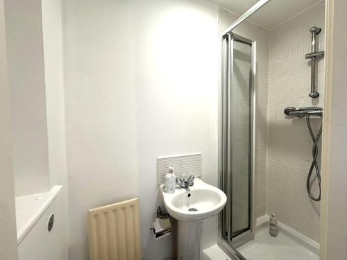格拉斯哥Private room with en-suite and parking in shared flat的白色的浴室设有水槽和淋浴。