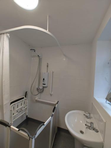 利物浦Anstuns LODGE的白色的浴室设有水槽和淋浴。