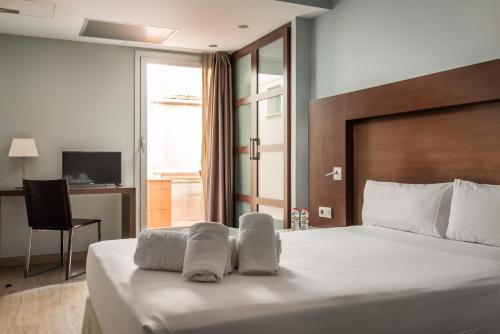 略夫雷加特河畔奥斯皮塔莱特马达尼斯里塞奥酒店的酒店客房,配有带毛巾的床