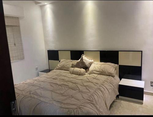 安曼Apartment in Amman 7th circle的一间卧室配有一张大床和木制床头板